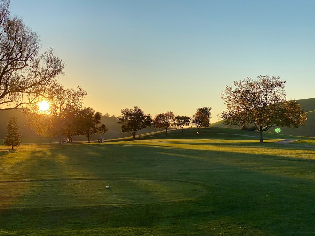 Panoramic view of a lush green golf course at Spring Valley Golf Course. Smooth