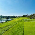 Panoramic view of a lush green golf course at Stonewall. Smooth