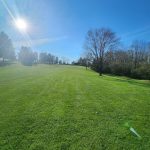 Panoramic view of a lush green golf course at Stoughton Acres Golf Course. Smooth