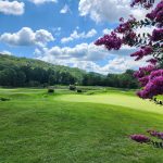 Panoramic view of a lush green golf course at Sugarwood Golf Course. Smooth