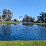 Panoramic view of a lush green golf course at Sun Village Golf Course. Smooth