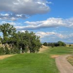 Panoramic view of a lush green golf course at Sundance Country Club. Smooth