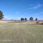 Panoramic view of a lush green golf course at Sunrise Vista Golf Course. Smooth