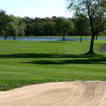 Panoramic view of a lush green golf course at Swan Lake Golf Club. Smooth