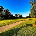 Panoramic view of a lush green golf course at Swan Lake Golf Course. Smooth