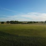 Panoramic view of a lush green golf course at Sweetwater Golf Course. Smooth
