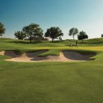 Panoramic view of a lush green golf course at TPC Las Colinas. Smooth
