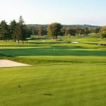 Panoramic view of a lush green golf course at Tamarack Country Club. Smooth