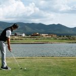 Panoramic view of a lush green golf course at Taos Country Club. Smooth
