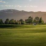 Panoramic view of a lush green golf course at Teton Reserve. Smooth