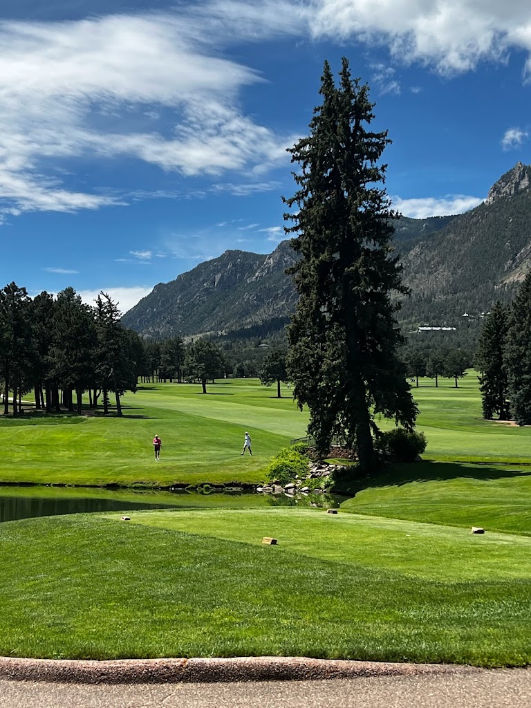 Panoramic view of a lush green golf course at The Broadmoor Golf Club. Smooth
