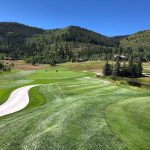 Panoramic view of a lush green golf course at The Club At Cordillera - Mountain Course. Smooth