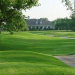 Panoramic view of a lush green golf course at The Club at Forest Ridge. Smooth