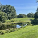 Panoramic view of a lush green golf course at The Fairways at Twin Lakes. Smooth