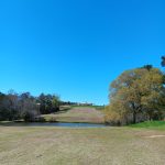 Panoramic view of a lush green golf course at The Fields Golf Club. Smooth