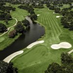 Panoramic view of a lush green golf course at The Golf Club at Cinco Ranch. Smooth