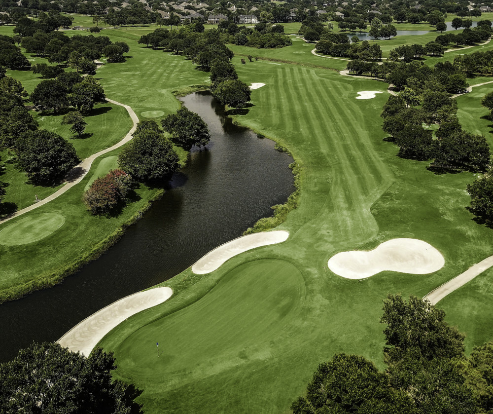 Panoramic view of a lush green golf course at The Golf Club at Cinco Ranch. Smooth