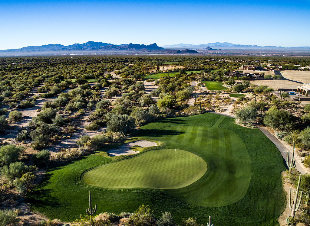 Panoramic view of a lush green golf course at The Golf Club at Dove Mountain. Smooth