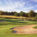 Panoramic view of a lush green golf course at The Golf Club at Fossil Creek. Smooth