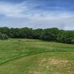 Panoramic view of a lush green golf course at The Golf Club at Table Creek. Smooth