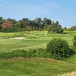 Panoramic view of a lush green golf course at The Greens at Prairie Hills. Smooth