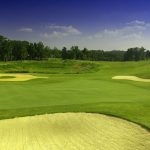 Panoramic view of a lush green golf course at The Legacy Golf Course. Smooth