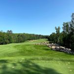 Panoramic view of a lush green golf course at The Legend at Giants Ridge. Smooth