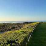 Panoramic view of a lush green golf course at The Links at Spanish Bay. Smooth