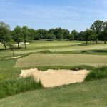 Panoramic view of a lush green golf course at The Loop. Smooth