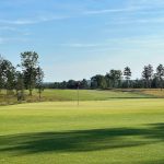 Panoramic view of a lush green golf course at The Loop. Smooth