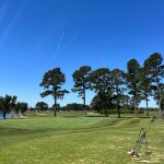 Panoramic view of a lush green golf course at The Man O' War Golf Club. Smooth
