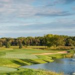 Panoramic view of a lush green golf course at The Meadows at Mystic Lake. Smooth