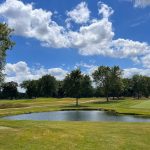 Panoramic view of a lush green golf course at The Oak Park Country Club. Smooth