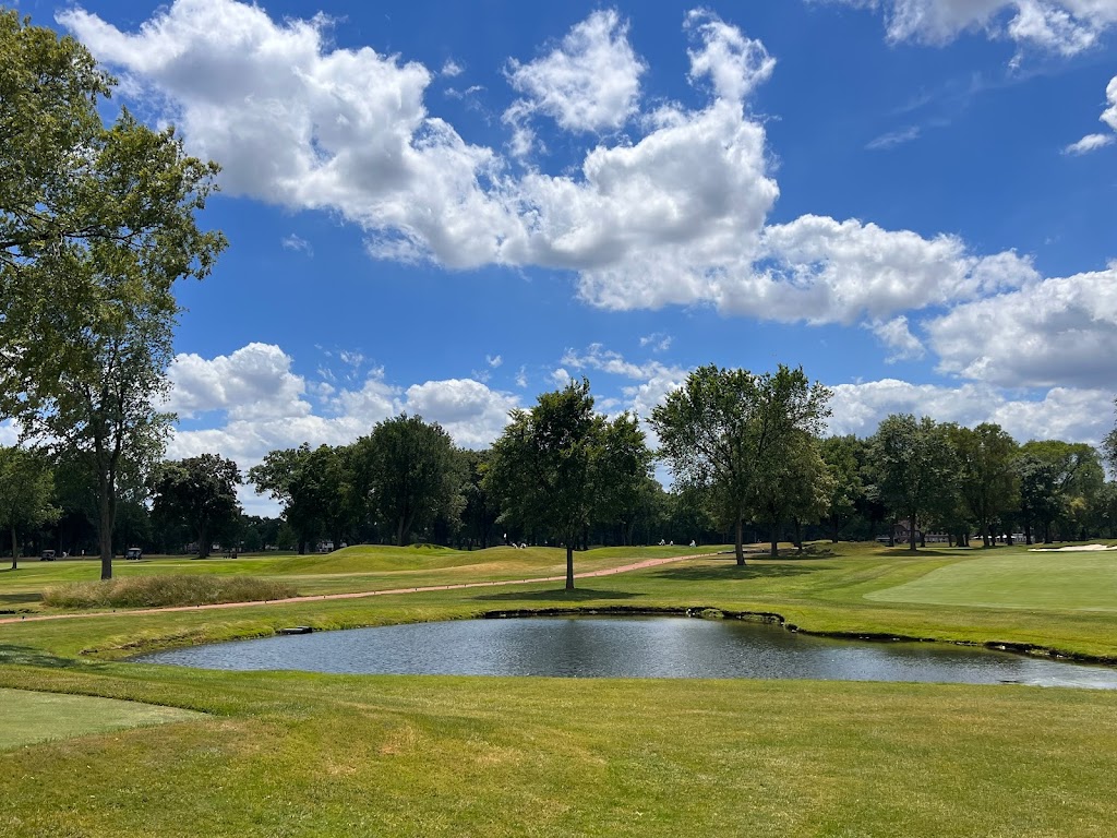 Panoramic view of a lush green golf course at The Oak Park Country Club. Smooth