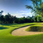 Panoramic view of a lush green golf course at The Oaks Golf Club. Smooth