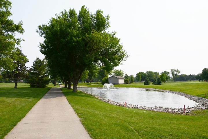 Panoramic view of a lush green golf course at The Pines Country Club. Smooth