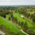 Panoramic view of a lush green golf course at The Pines Golf Course. Smooth