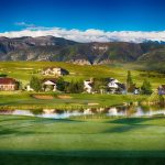 Panoramic view of a lush green golf course at The Powder Horn Golf Club. Smooth