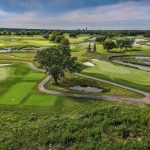Panoramic view of a lush green golf course at The Preserve at Oak Meadows. Smooth