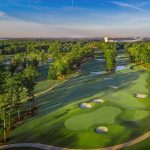 Panoramic view of a lush green golf course at The Refuge Golf Course. Smooth
