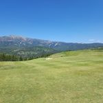 Panoramic view of a lush green golf course at The Reserve at Moonlight Basin. Smooth