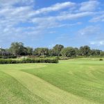 Panoramic view of a lush green golf course at The Ritz-Carlton Members Golf Club. Smooth