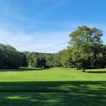Panoramic view of a lush green golf course at The Tradition Golf Club at Oak Lane. Smooth