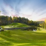Panoramic view of a lush green golf course at The Wilderness at Fortune Bay. Smooth