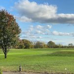 Panoramic view of a lush green golf course at Thoroughbred Golf Club. Smooth