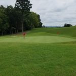 Panoramic view of a lush green golf course at Three Ridges Golf Course. Smooth