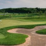 Panoramic view of a lush green golf course at Thunderhawk Golf Club. Smooth