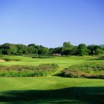 Panoramic view of a lush green golf course at Tierra Verde Golf Club. Smooth