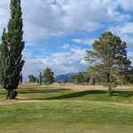 Panoramic view of a lush green golf course at Tijeras Arroyo Golf Course. Smooth