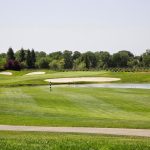 Panoramic view of a lush green golf course at Timber Creek Golf Course. Smooth